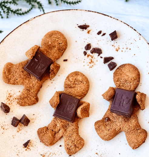 Three ginger bread men carrying hu chocolate bars