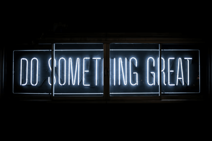 A stylized neon sign saying "DO SOMETHING GREAT"