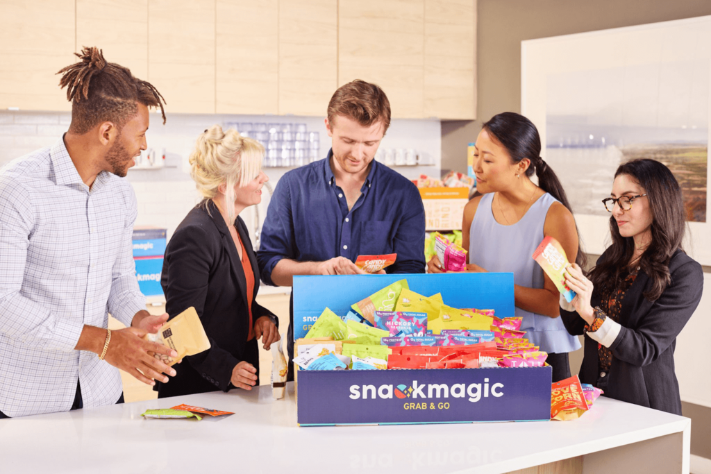 Coworkers enjoying a snackmagic box full of custom treats and bites.